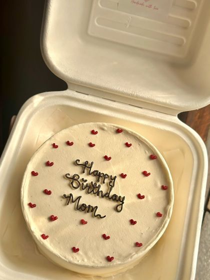 A sweet and simple bento cake for a mom's birthday, dotted with tiny red hearts. We made this one in our popular lemon raspberry flavor with homemade compote.