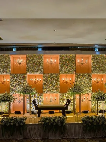 This engagement and reception stage combines floral panels with inset chandeliers for a warm, classic look. The design provides beautiful, soft lighting and a sense of timeless elegance.