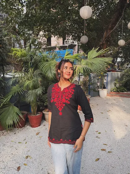 A sunny, happy picture in a black kurti with red embroidery, paired with jeans for a casual ethnic look.