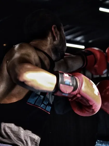 A female fighter sparring with a male partner, working on her defense against a stronger opponent. Our gym is for everyone who is serious about the sport, man or woman.