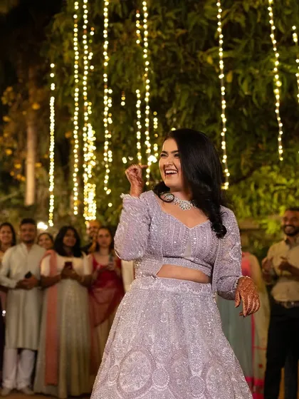 A candid moment of joy from the Sangeet night. The bride's radiant makeup enhances her happy expression as she dances with her loved ones.