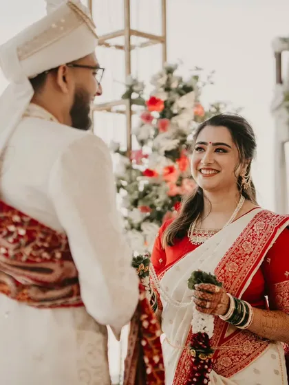 Beautiful captures from the Varmala ceremony. The bride's look is simple and elegant, with a classic red and white saree.