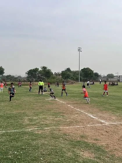 A wide view of a U11 match in progress at the Junior League, showing players spread across the field.