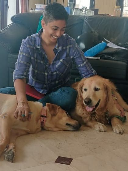 A fellow trainer relaxes with two golden retrievers. Our community is built on a shared love and respect for animals.