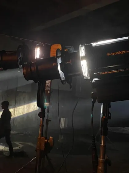 This behind the scenes shot shows the tools used to create dramatic lighting. We used a Dedolight DLED9 and a 400W HMI, both with projector lenses, to create sharp, controllable beams and stripes of light on the character and set.