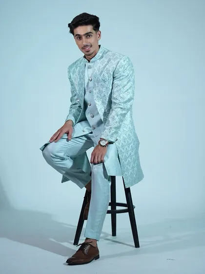 A seated pose in our light blue sherwani, showing how comfortable and stylish our ethnic wear is.