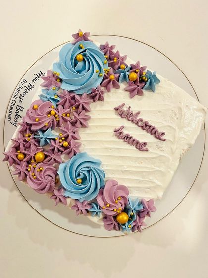Sheet cakes have my heart. This design features a beautiful arrangement of piped buttercream flowers in shades of blue and purple, accented with gold sprinkles.