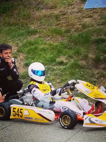 A coach provides one-on-one guidance to driver Rishon Magehalli at the FIA World Championship Academy Trophy in Germany.