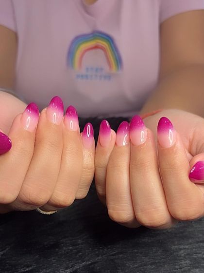 A full view of the beautiful pink ombré nails.