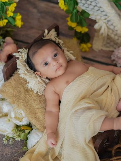 A happy little camper. This awake shot captures a beautiful smile from a baby enjoying the cozy, rustic setup.