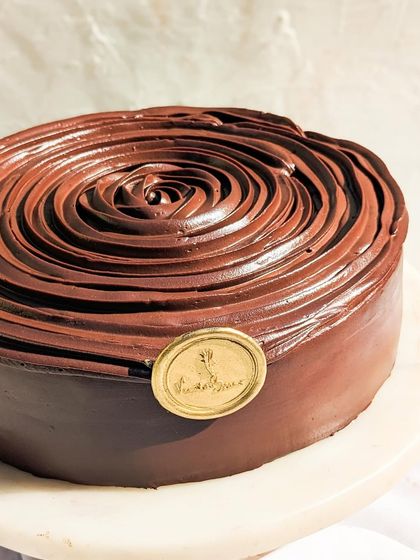 A close-up of our Belgian Dark Chocolate cake, showcasing the beautiful rose piping. This cake is for true chocolate lovers who appreciate a deep, authentic cocoa flavor.