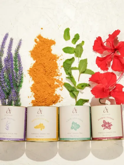 A creative flat-lay of four different herbal tea blends, with their respective ingredients like lavender, turmeric, and hibiscus flowers arranged beautifully. This shot showcases the variety and natural origins of the products.
