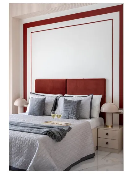 A cozy guest bedroom retreat. The brick-red headboard and blush-pink walls create a warm and inviting atmosphere, perfect for making visitors feel at home.