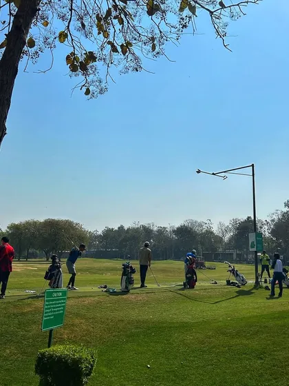 A peaceful corner of the range on a sunny Saturday, with a few golfers enjoying the quiet.
