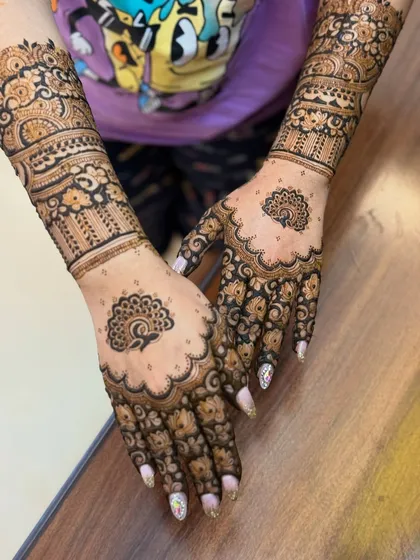 Another view of the peacock design, showing the intricate patterns on the fingers and wrists.