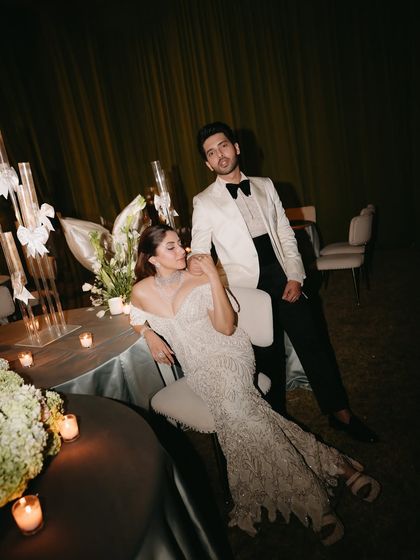 A stunning portrait of the couple during their "Big Bow Affair" reception. The soft lighting and elegant decor create a timeless and romantic mood.
