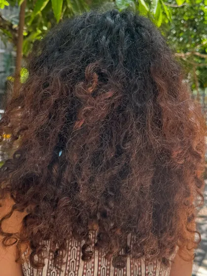 From frizzy and faded to defined and vibrant. This transformation included a no-bleach balayage to refresh her old color and a shaping cut to bring her curls back to life.