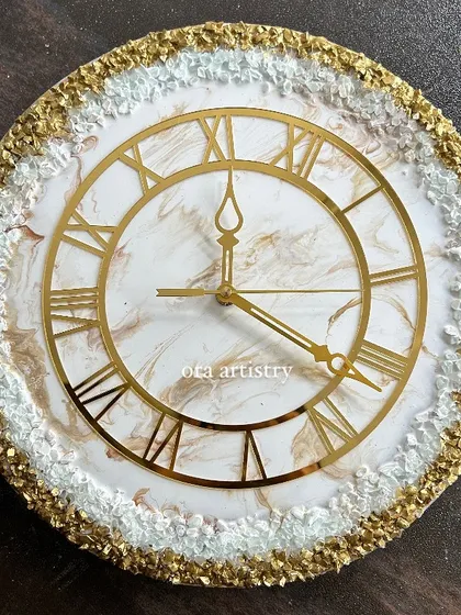 A beautiful clock with a gold and white crystal border and a subtle marbled center. The Roman numerals add a classic touch.