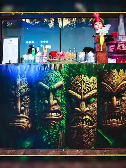 This bar counter with bold, tribal tiki mask designs makes a powerful statement. It's perfect for a tropical or jungle-themed party, immediately setting a unique and adventurous tone.