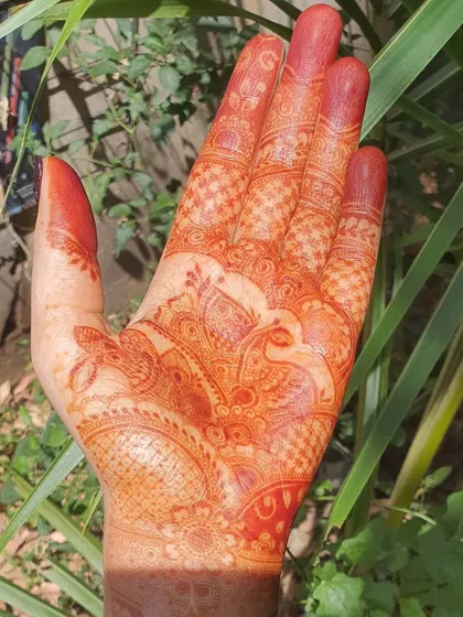 A lovely, bright orange fresh stain from a bridal design featuring a peacock motif. This initial color is the first step in the journey to a deep, long-lasting maroon stain.