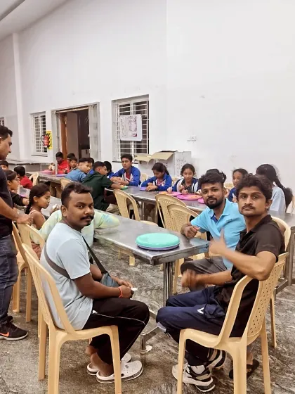 Instructors and parents sitting with the students during a meal break. It's a community effort.