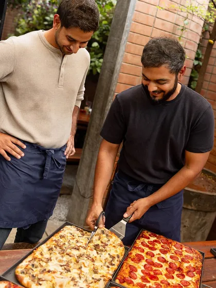 Cutting the Pizza Romana with scissors, the traditional way. It's all smiles as we prepare to serve our new creations.