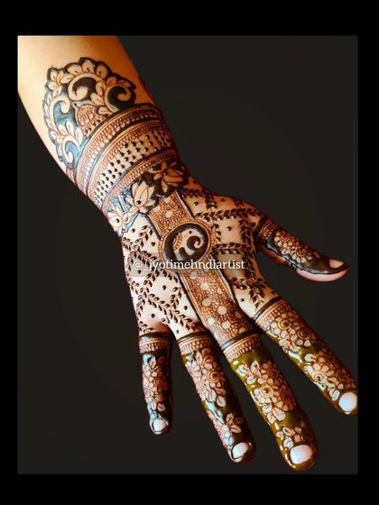 A creative back-of-hand design featuring a baby elephant, floral elements, and paisley patterns for a unique and traditional look.