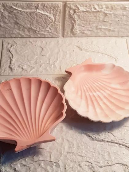 Two of our mini shell dishes in shades of pink, one solid and one with a marble effect.