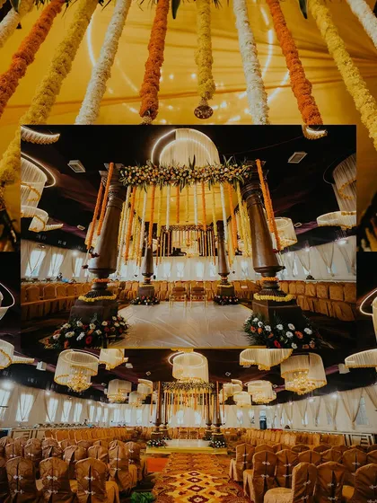 A wide-angle view of the magnificent indoor mandap, decorated with traditional marigold garlands and wooden pillars.
