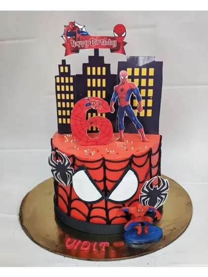 Here's a Spiderman cake with a unique two-part design. The bottom tier features his iconic mask, while the top shows him swinging over the city skyline, all made with a delicious fresh pineapple flavor.