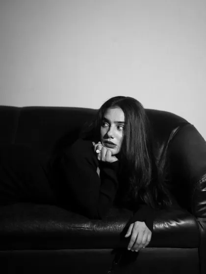 A studio session with a model in a black dress, showcasing a range of poses from pensive to powerful. The lighting is controlled to sculpt the subject and create a sophisticated mood.