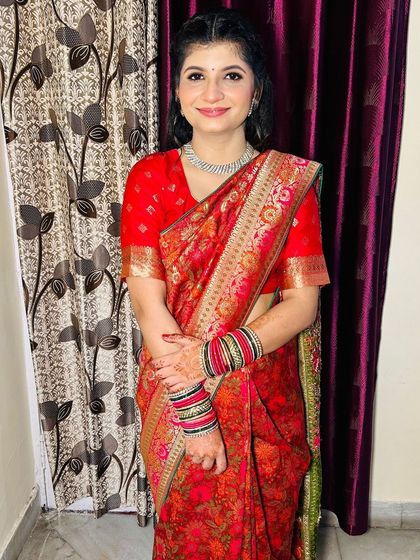 A full-length view of the Roka bride, looking graceful in her traditional red saree.