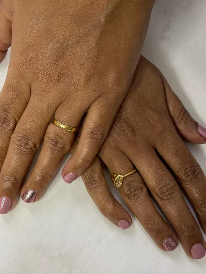 This image shows a simple gel polish application on natural nails. The look combines a soft mauve color with a rose gold glitter accent nail for a chic and low-maintenance manicure.