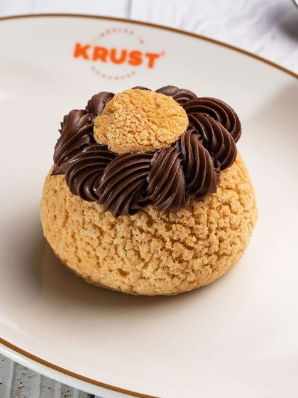 A close-up of the expertly piped chocolate cream on our choux pastry. I take pride in the details, ensuring every pastry is as beautiful as it is delicious.