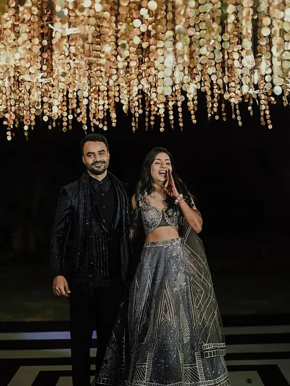 A full view of the couple under the stunning ceiling installation. The geometric dance floor and shimmering lights came together for a truly memorable reception look.