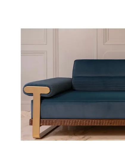A detail of the comfy and classy blue couch, showing the brass armrest and velvety textured fabric.