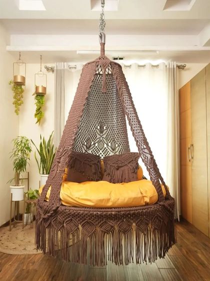 This dual seater swing in a light brown color offers a neutral, earthy tone that complements many decor styles. The macrame-detailed pillows are included.