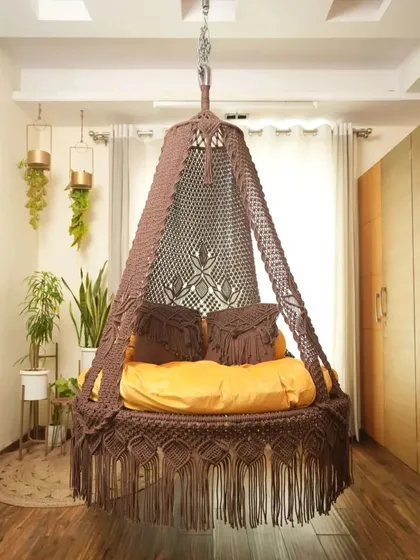This dual seater swing in a light brown color offers a neutral, earthy tone that complements many decor styles. The macrame-detailed pillows are included.