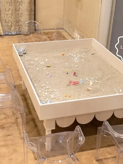 A sand play table where kids could dig for "treasure" like shells, pearls, and miniature mermaid figures.