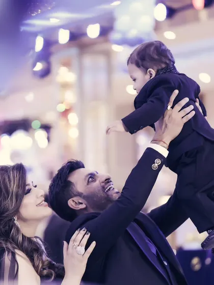 A beautiful candid moment from a birthday party, with a father lifting his son in the air.