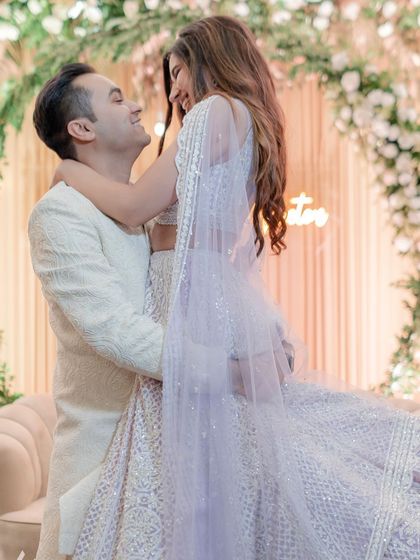 The groom lifts his bride in a joyful embrace during their engagement ceremony. This photo is full of life, love, and the excitement of starting a new chapter together.