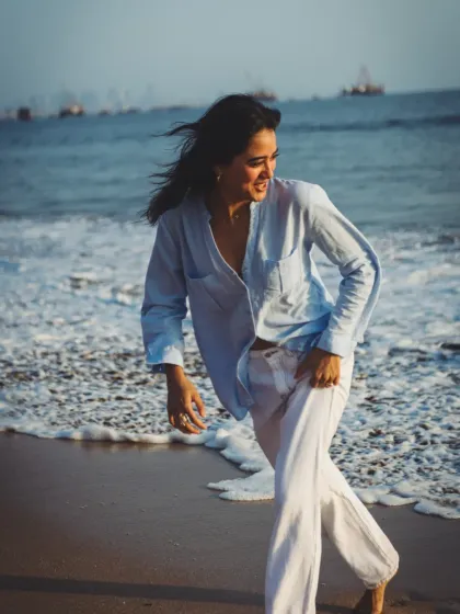 A candid moment of joy and movement on the shoreline. This image feels spontaneous and alive, perfect for a lifestyle fashion campaign.