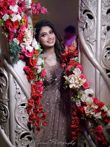 A beautiful portrait of the bride framed by flowers, showcasing her smile and elegant attire.