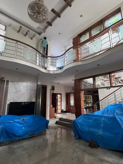 I handle projects of all sizes, including large duplex homes with high ceilings and complex layouts. This photo shows my team carefully prepping a spacious living area, ensuring all furniture is securely covered before we begin the interior painting process.