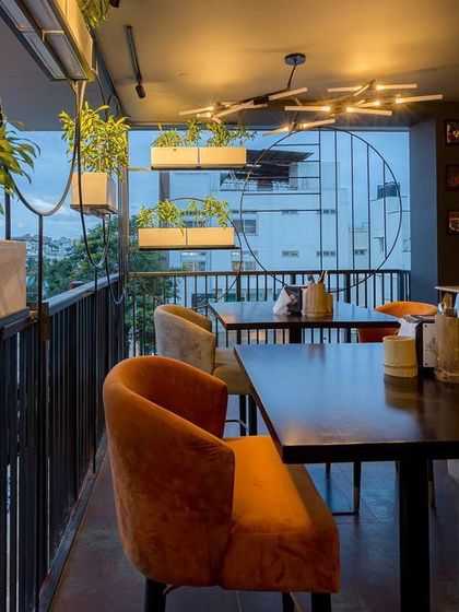 Safety can be stylish. For this balcony seating area, we designed an innovative safety grill that doubles as a decorative screen, complete with integrated planters that bring greenery and life to the edge of the space.