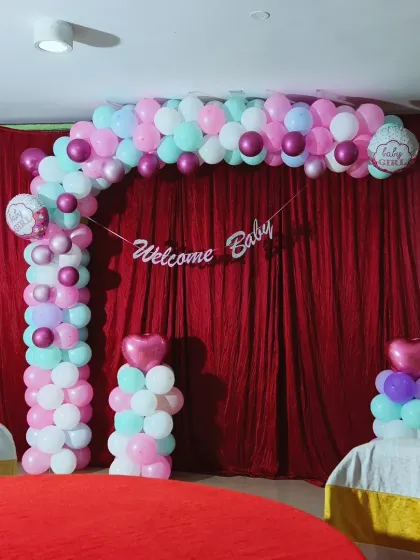 A sweet and simple 'Welcome Baby Girl' decoration with a pastel balloon arch, perfect for a small gathering or home celebration.