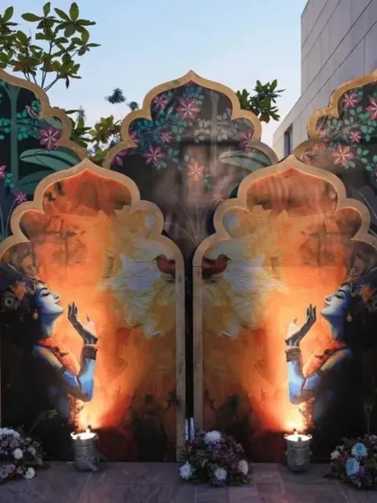 A stunning and artistic backdrop for a Krishna party, featuring beautiful paintings and lit by candles for a serene evening event.
