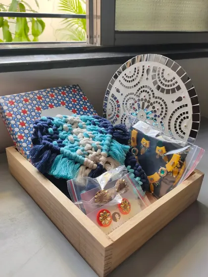 For this hamper, I combined a dark blue macrame purse with a set of my handmade earrings and a mirror mosaic wall hanging. It’s a perfect blend of personal accessories and home decor.