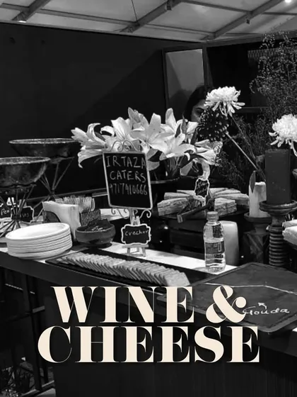 A chic and moody shot of a wine and cheese station, perfect for a corporate networking event. The black and white photo emphasizes the elegant lines and sophisticated atmosphere.