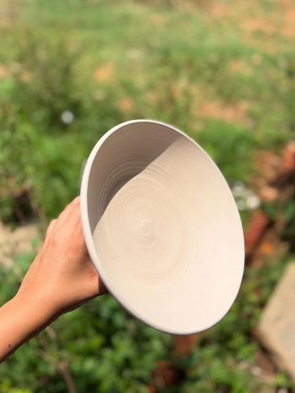 The interior of the unglazed bowl, showing the spiral throwing rings that are a signature of wheel-thrown pottery.